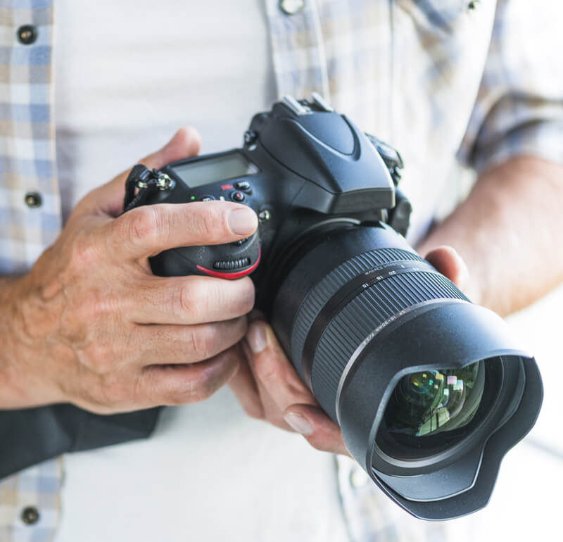 dłonie trzymające aparat fotograficzny